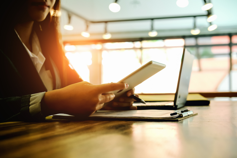 Pessoa no computador e com tablet na mão analisando estratégias online